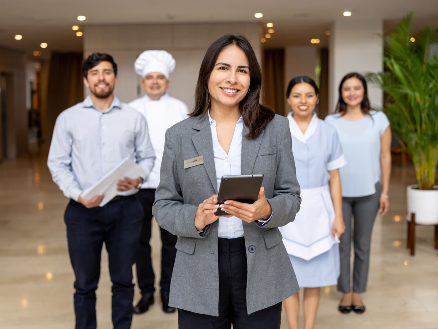 Serviceteam eines Hotels in der Lobby, die Objektleiterin im Vordergrund