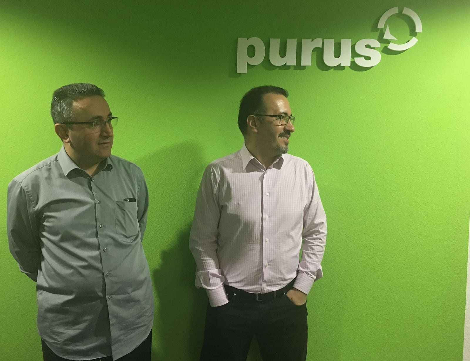 Haci Güventürk und sein Bruder Ilhami vor der Wand mit dem purus-Logo